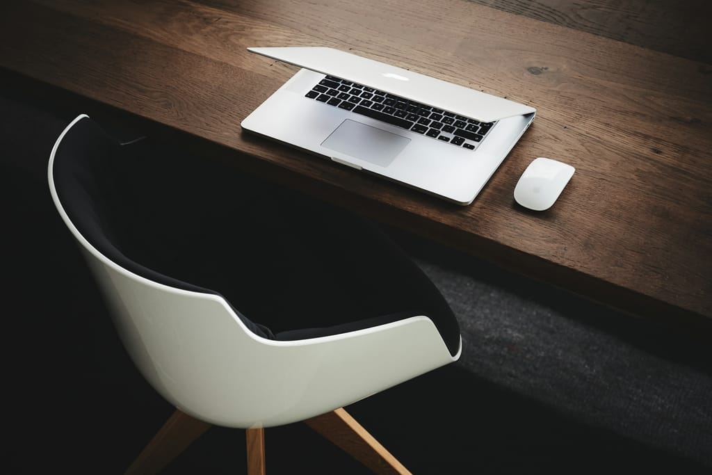 A clean office desk with a laptop and notebook, representing the CoreGoods trade contact desk.